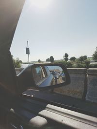 Close-up of car on side-view mirror against clear sky