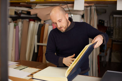 Man reading book at table