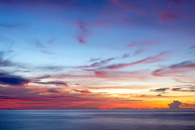 Scenic view of sea against dramatic sky during sunset