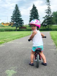 Rear view of cute girl riding bicycle at park