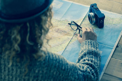 High angle view of woman holding eyeglasses on world map