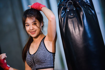 Portrait of female boxer standing against wall