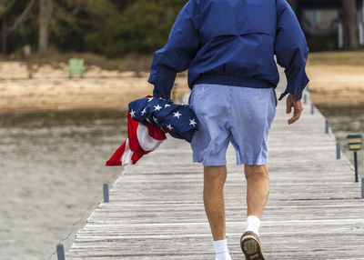 Rear view of a man carrying water