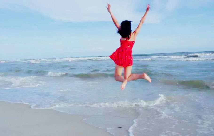 sea, water, horizon over water, full length, beach, leisure activity, lifestyles, shore, sky, vacations, arms outstretched, wave, jumping, person, enjoyment, carefree, young adult, arms raised