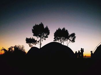 Silhouette trees against sky at dusk