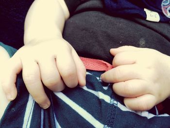Close-up of baby hands on bed