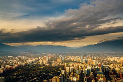 Aerial view of cityscape against cloudy sky