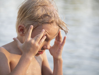 Close-up of shirtless boy at lakeshore