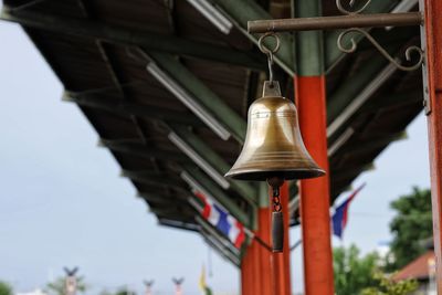 Low angle view of bell hanging by building