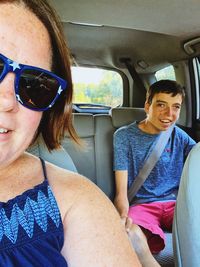 Portrait of woman wearing sunglasses sitting in car