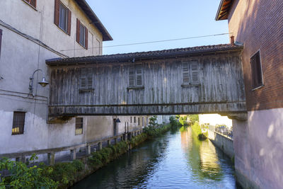 Canal amidst buildings in town against sky