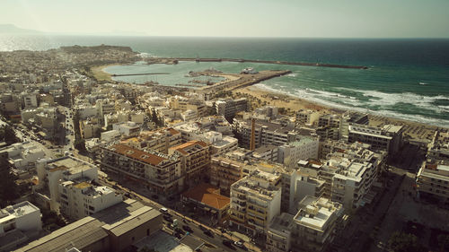 High angle view of buildings and sea against sky