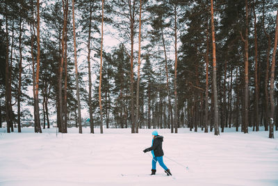 Man skiing on snow covered forest