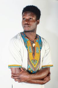 Portrait of young man standing against white background