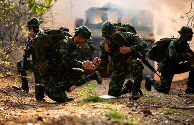 People in camouflage clothing holding weapon