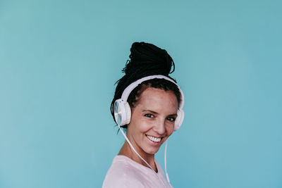 Portrait of a smiling young woman against blue background