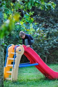 Rear view of a baby boy on slide at park