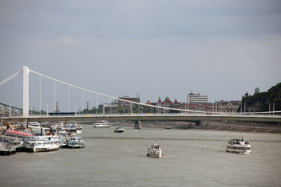 Bridge over river in city against sky