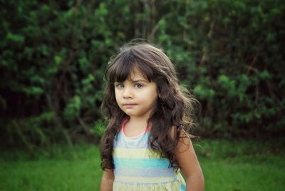 Portrait of girl standing on grassy field