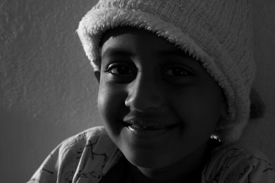 Portrait of smiling boy wearing hat against wall