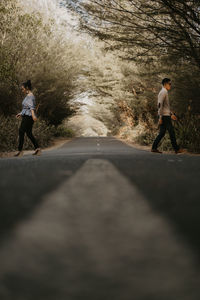 People walking on road amidst trees