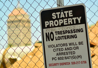 Close-up of warning sign on fence