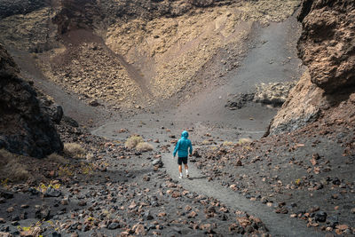 Rear view of man walking on rocks