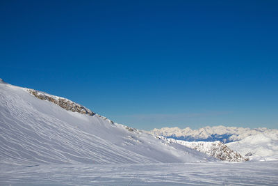 Snowcapped mountains against clear blue sky