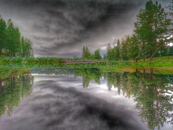 Scenic view of trees against cloudy sky