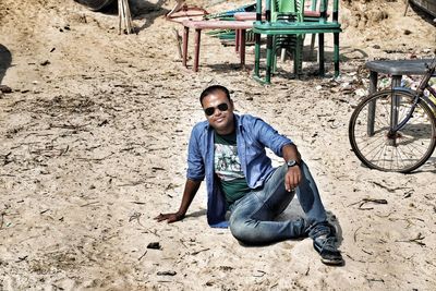 Portrait of young man sitting on land