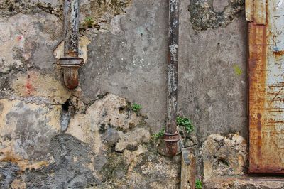 Close-up of rusty pipe against door