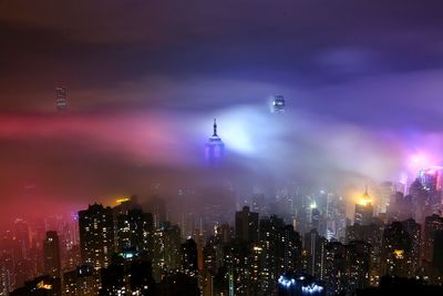 Illuminated city against sky at night