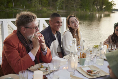 Family having dinner by lake