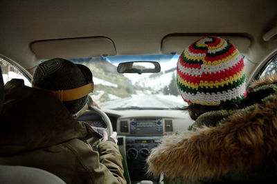 Rear view of friends sitting in car