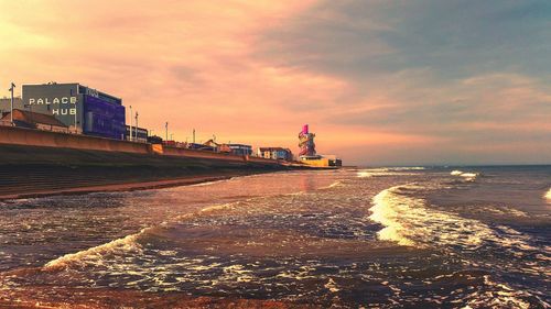 Scenic view of beach by sea against sky during sunset