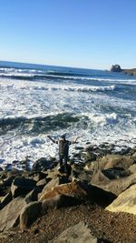 Man standing on beach against clear sky