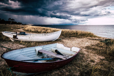 Boats moored on shore against sky