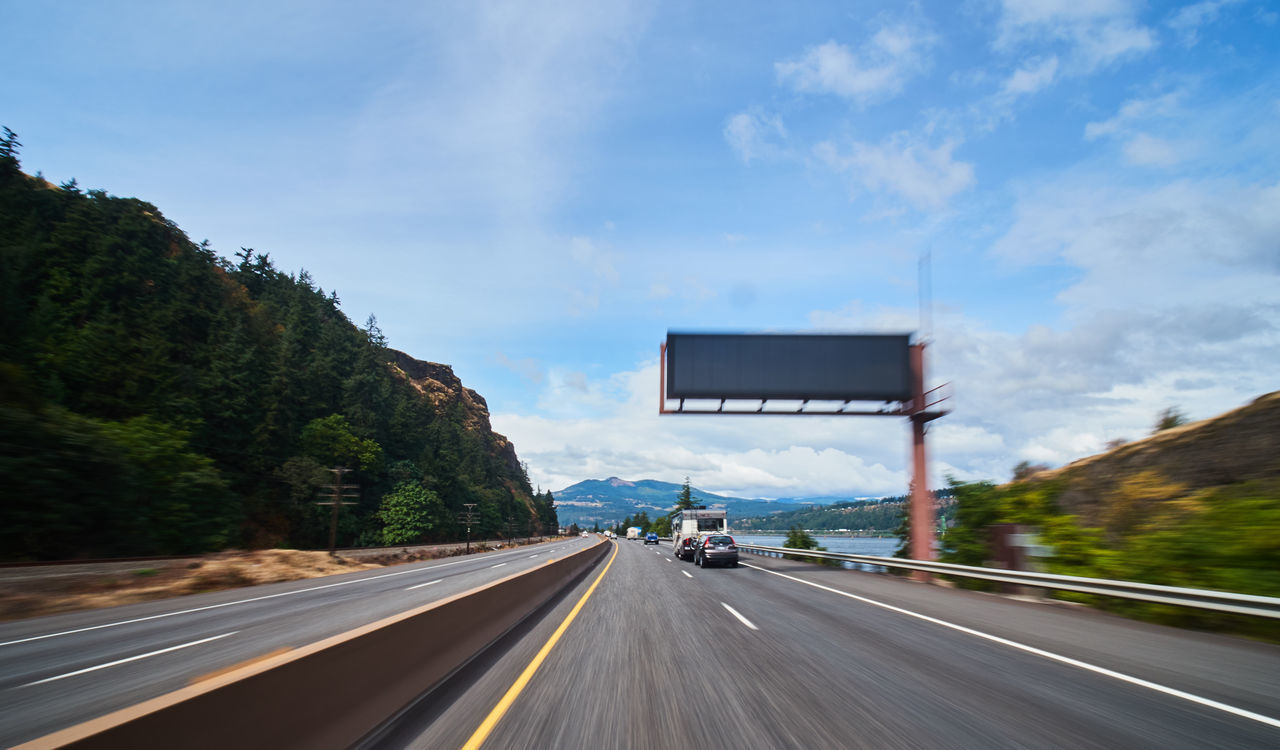 ROAD BY MOUNTAINS AGAINST SKY