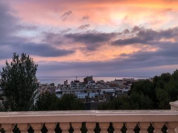 High angle view of trees and buildings against sky at sunset