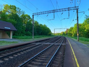 Railroad tracks by trees against sky