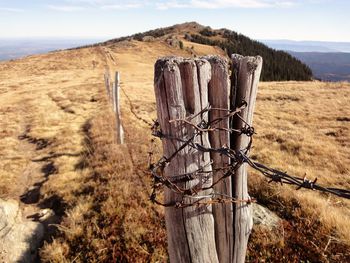 View of wooden post on field against sky