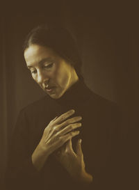 Portrait of young man against black background