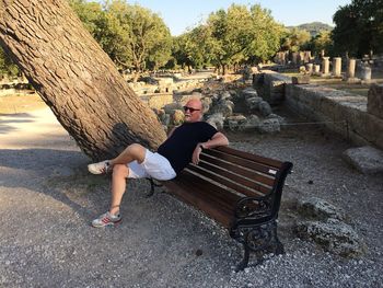 Full length portrait of woman sitting on bench