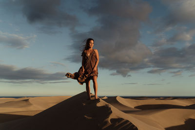 Woman standing by sea against sky