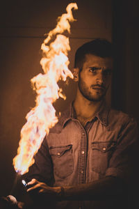 Portrait of young man holding fire