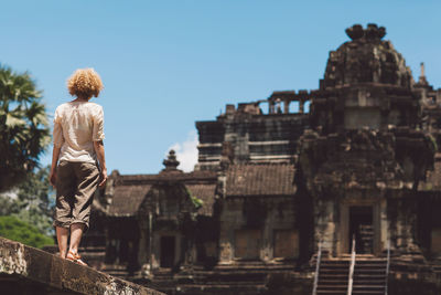 Rear view of man against built structure