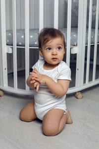 Portrait of cute baby boy sitting on floor