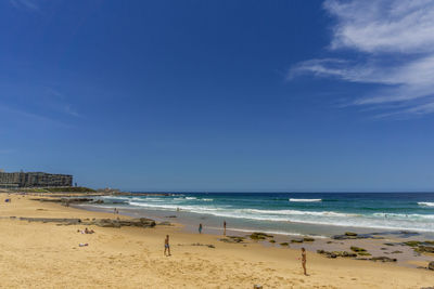 Scenic view of beach against blue sky