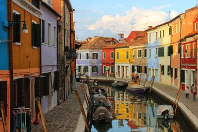 Boats in canal amidst buildings in city