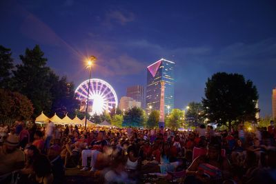 People at centennial olympic park against sky at night